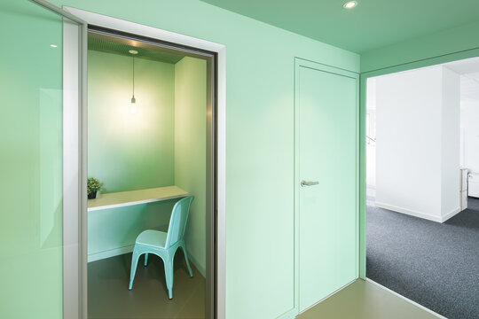 Mint green coworking office with private work booth