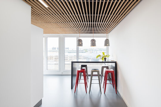 Modern coworking office with high table and red stools