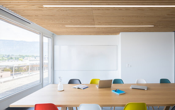 Modern coworking office with table, laptop and colorful chairs