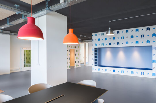 Modern coworking office interior with colorful pendant lamps