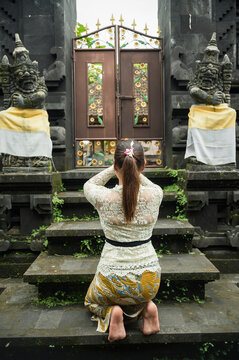 Woman pray at Balinese Hindu temple gate