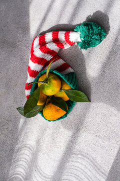 Christmas oranges in striped stocking with winter shadow