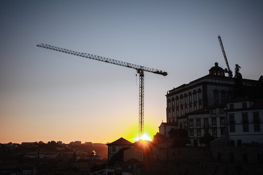 Sunset over Porto skyline with construction cranes