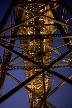 Illuminated steel bridge structure in Porto at night