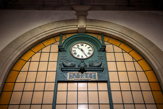 Historic Porto station clock beneath an arched window