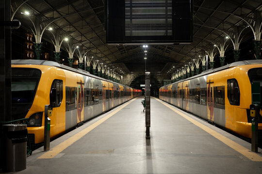 Yellow trains at Porto railway station platform at night