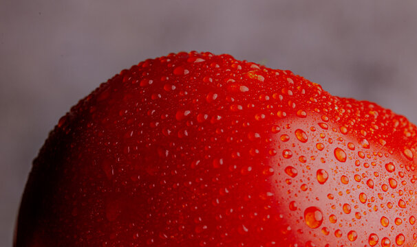 Macro red tomato skin texture with water droplet detail