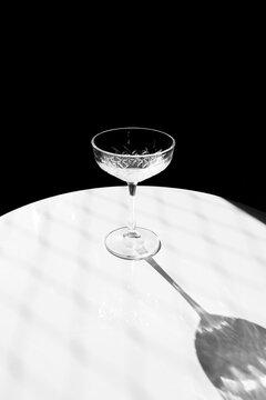 Empty cocktail glass with shadow on marble table