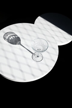 Empty cocktail glass on table in dark studio setting