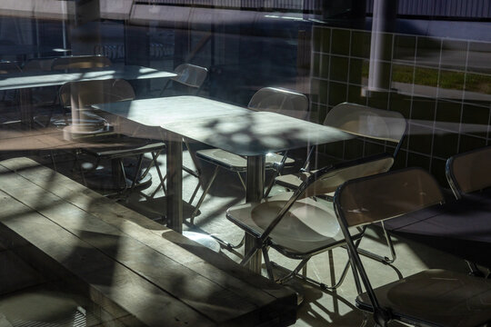 Sunlit empty cafe interior with reflection and shadow play