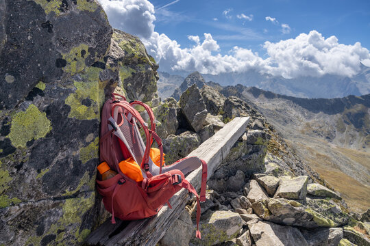Hiking backpack on rocky mountain ridge under cloudy sky