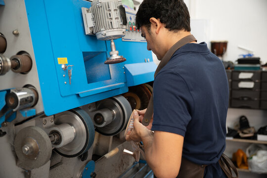 Shoemaker repair leather shoe with industrial grinding machine