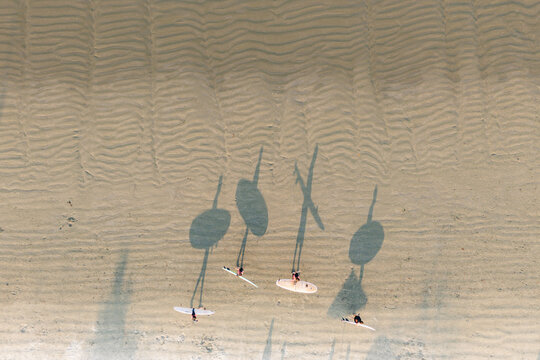 Aerial view of surfers and shadows on Ubatuba beach