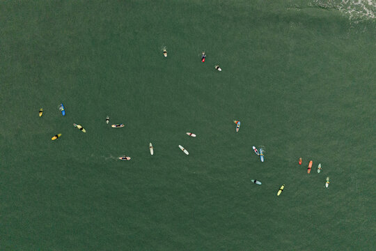 Aerial view of surfers and surfboard in Ubatuba sea