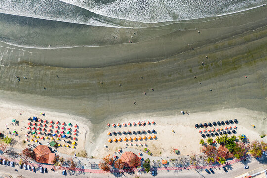 Aerial view of beach umbrellas and surf in Ubatuba, Brazil