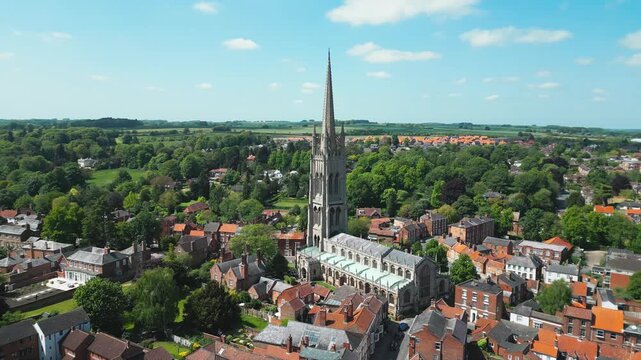 Aerial view of historic church spire rising above quaint town