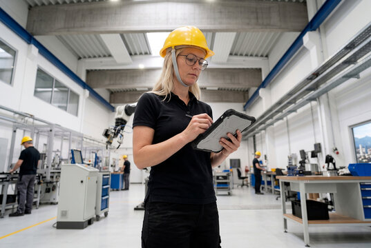 Female engineer with tablet in modern manufacturing facility