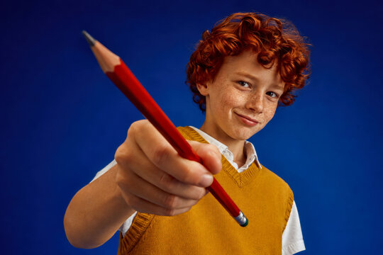 Schoolboy holding pencil for back to school education