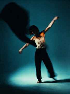 Blurred contemporary dancer moving in dramatic studio light