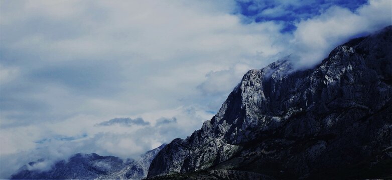Big mountain with high peak and white dramatic clouds above, mountain magnificent landscape