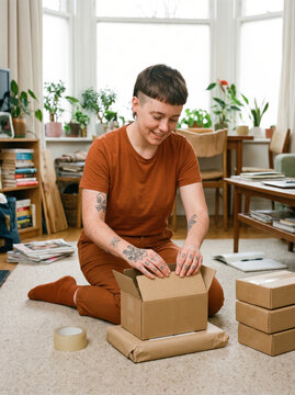 Person pack order in cardboard box at home