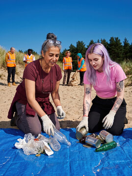 Volunteers sort beach waste during coastal cleanup effort
