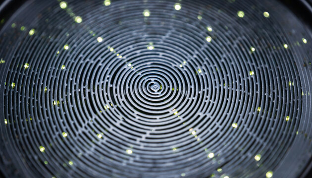 Dark circular metallic spiral with glowing yellow light points