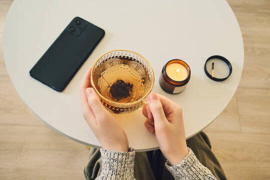 Cozy evening ritual with tea and candlelight. Digital detox concept