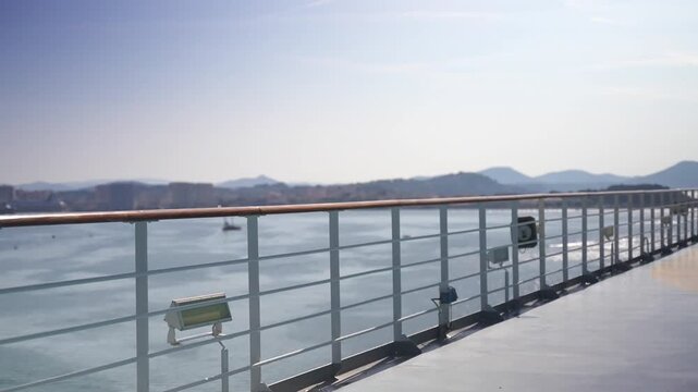 Static coastal view from a ship deck with white railings