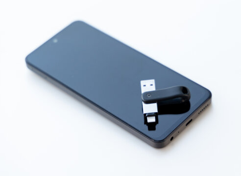 A dual connector flash drive sitting on a smartphone display