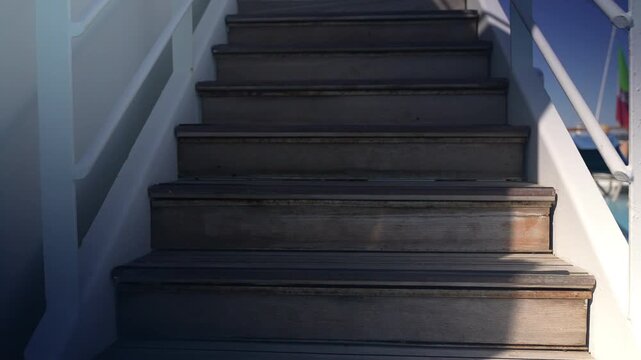 Camera ascending cruise ship stairs beneath a clear blue sky