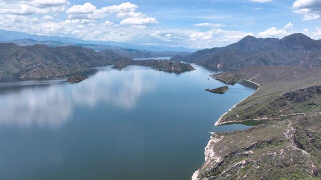 El Quimbo Reservoir Surrounded by Mountains along the Magdalena River in Huila, Colombia. Establishing Shot. Aerial View.