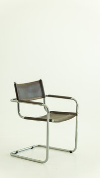 Modernist cantilever chair with brown leather upholstery and a polished chrome metal frame