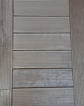 Brown composite decking with parallel grooves and wood grain texture