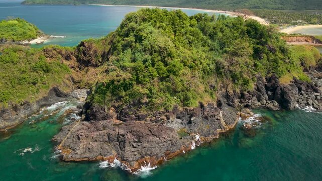 Drone footage over Nacpan and Calitang Twin Beach in El Nido, Palawan, capturing the distinctive shape of the two beaches, white sand shoreline and surrounding tropical landscape.