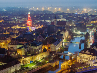 Panorama oświetlonego nocą zabytkowego starego miasta  Opole z lotu ptaka. Widok na rzekę, klimatyczne mosty, iluminacje architektury i zabytkową wieżę ratusza w centrum Europy. © Henryk Niestrój