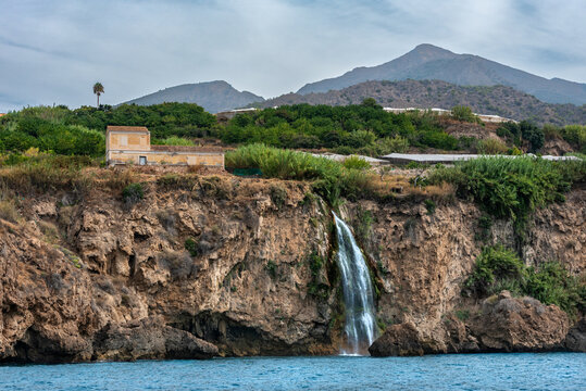Maro waterfall surrounded by cliffs in the Maro-Cerro Gordo natural area