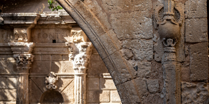 Close Architectural Shot of Stone Arch Ornament with Blurred Fountain Background