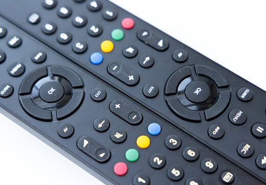 Two Black Remote Controls With Colorful Buttons Close Up
