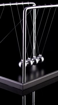 Newton's Cradle in slow motion. Vertical video.