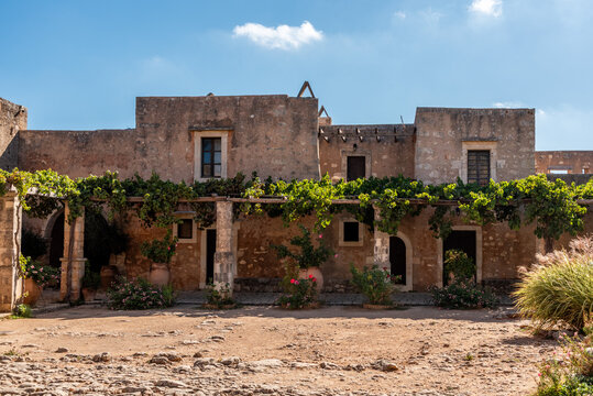 Arkadi, Greece - October 03, 2026 - Traditional Monks Cells Facade with Vine Covered Pergola at Arkadi Monastery