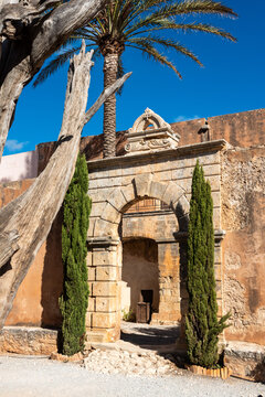 Arkadi, Greece - October 03, 2026 - Stone Arch Side Entry Gate in Wall at Arkadi Monastery