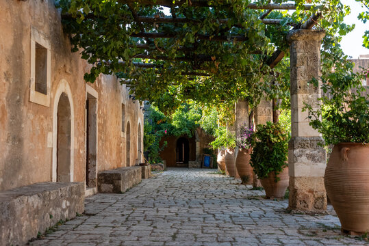 Arkadi, Greece - October 03, 2026 - Quiet Pergola Walkway with Terracotta Vases outside Monks Rooms at Arkadi Monastery