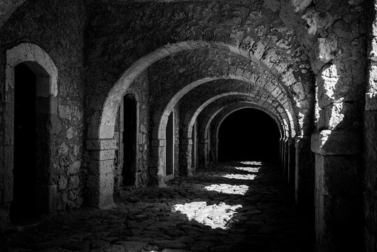 Arkadi, Greece - October 03, 2026 - Sunlight and Shadows along Vaulted Arcade Corridor at Arkadi Monastery