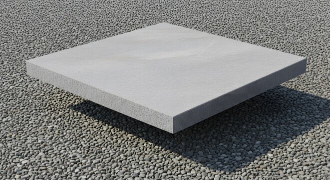 A single square concrete paving slab floating above a bed of gravel