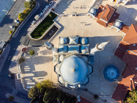 Vertical top down aerial view of the historic Zal Mahmut Pasha Mosque showcasing symmetric Ottoman domes and long shadows, Istanbul.