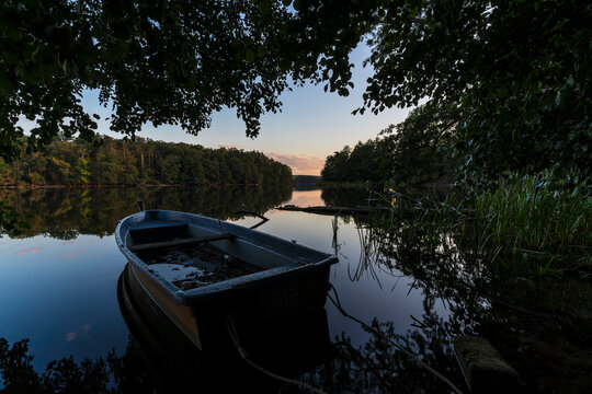 Sunset on the shore of calm lake.