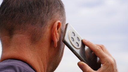 Mężczyzna rozmawiający przez telefon na świeżym powietrzu