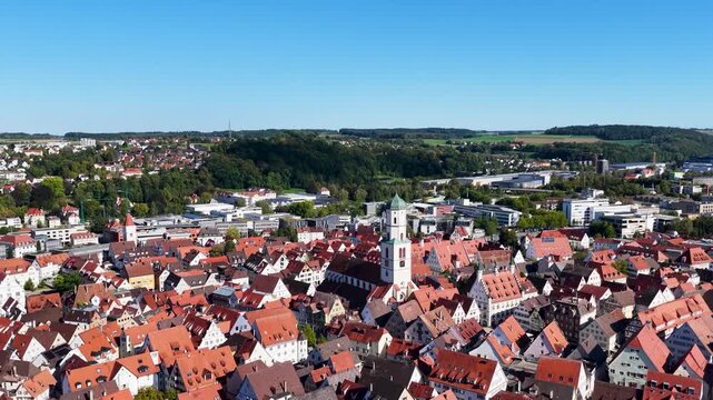 Malerische Panorama-Luftaufnahme von Biberach an der Ri&szlig; mit der historischen Altstadt, markanten Kircht&uuml;rmen und herbstlichen B&auml;umen unter blauem Himmel.