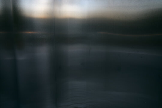 Abstract background featuring a smooth brushed metal surface with soft light reflections